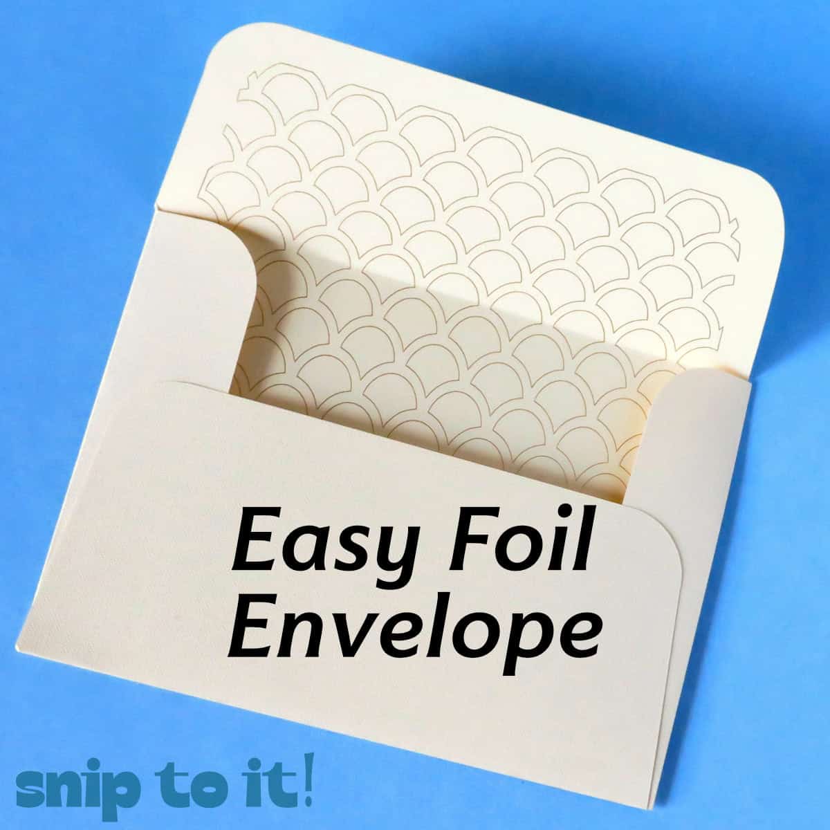 cream colored envelope with a gold seashell foil pattern on the inside flap, resting on a blue background. Text overlay reads Easy Foil Envelope