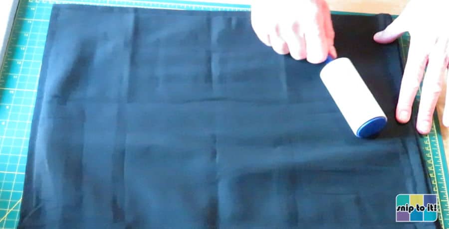 pillow cover being cleaned with a lint roller 