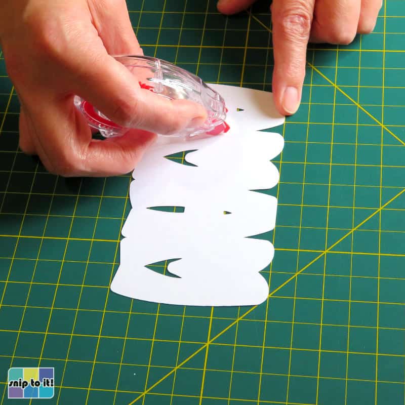 using tape runner to add adhesive to the back of the top layer of the mama design