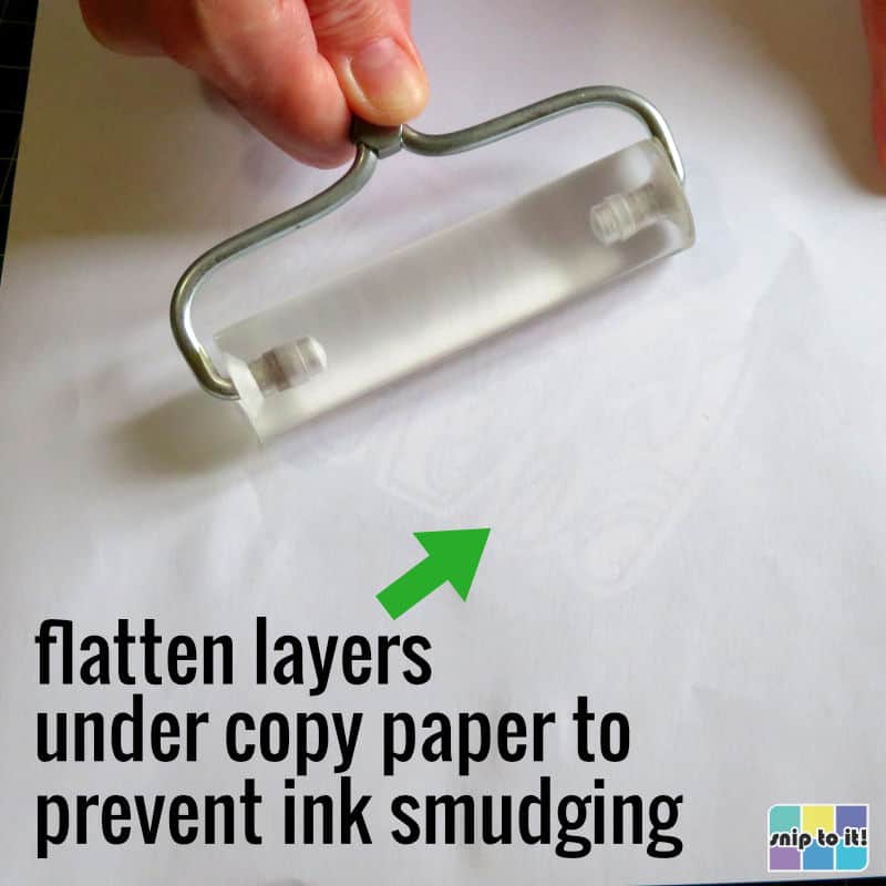 using a brayer to flatten layers together after adding top to middle layer of mama card