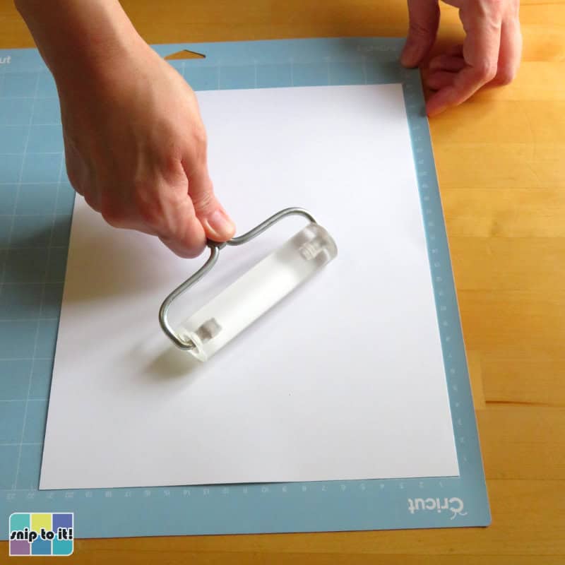 photo of applying the white layer of cardstock to the light grip mat using a brayer