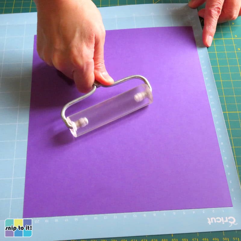 attaching the second/middle purple layer to the cutting mat using a brayer