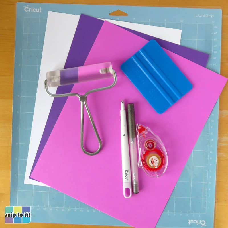 photo of supplies needed to make layered MOM and MAMA mother's day cards: cardstock in 3 colors, brayer, scoring stylus, pen, tape runner, and scraper tool