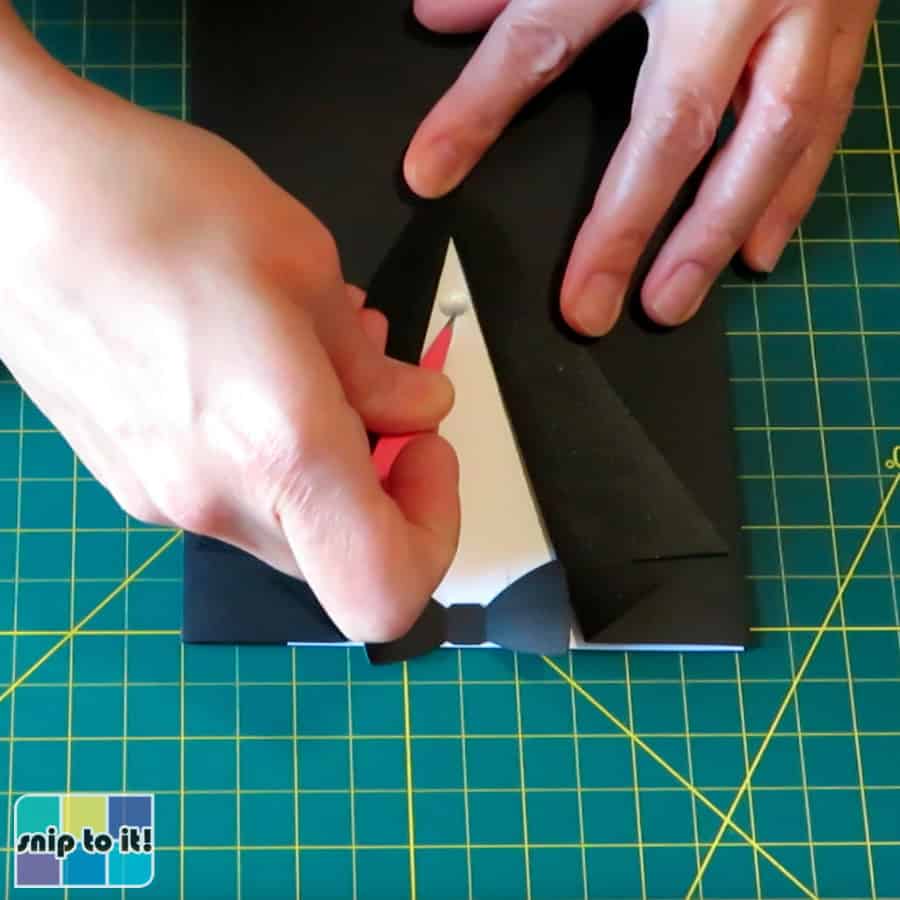 photo of placing the bottom button on the tuxedo envelope