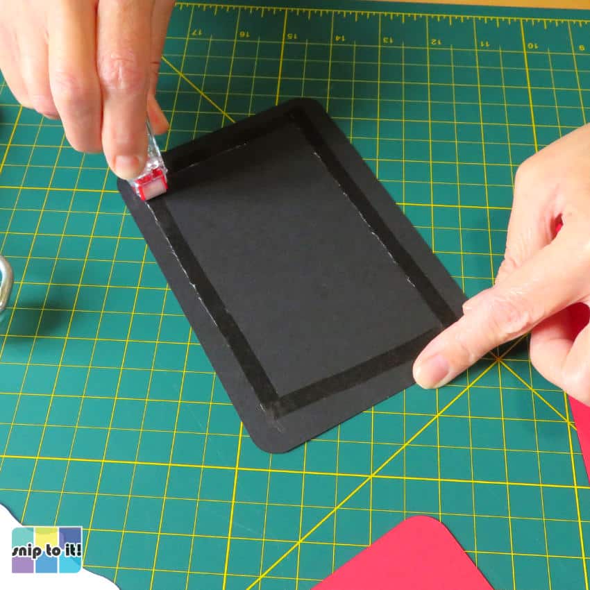 photo of adding tape runner to the back of the Goodfather cardstock panel