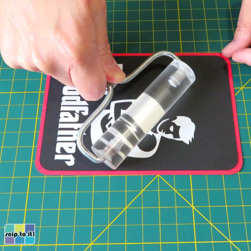 photo of rolling the Goodfather and red cardstock panels with a brayer to flatten and stick them together