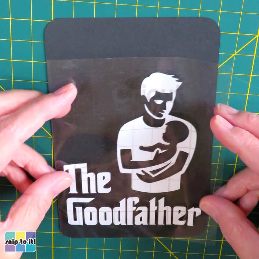 closeup image of adhesive vinyl on transfer tape being positioned over cardstock panel