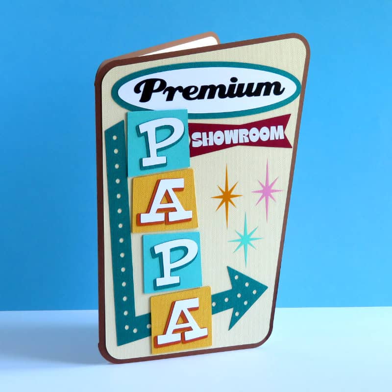 closeup of a finished mid-century modern inspired father's day card featuring the caption "Premium Papa showroom" with an arrow pointing inside the card.