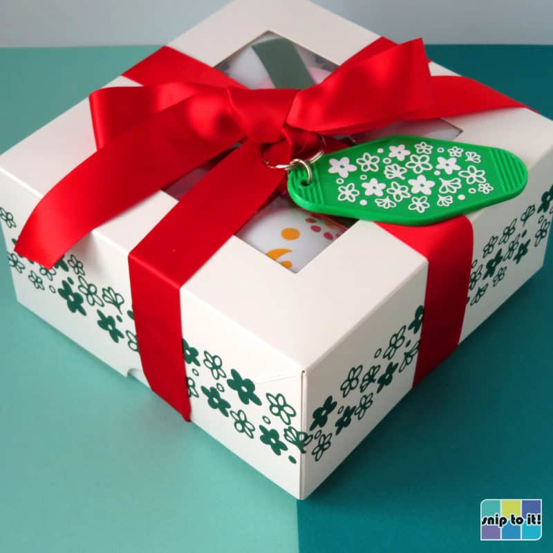 gift box of 4 christmas baubles, decorated with big red bow