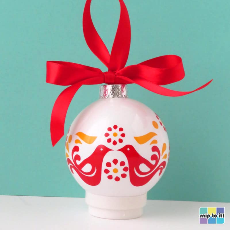 white christmas bauble decorated with red and yellow vinyl in pyrex friendship pattern