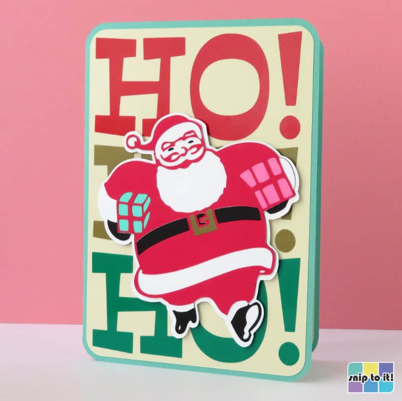 mid century style christmas card featuring HO HO HO in huge lettering stacked on the front of the card, with a vintage Santa with presents under each arm overtop of the lettering