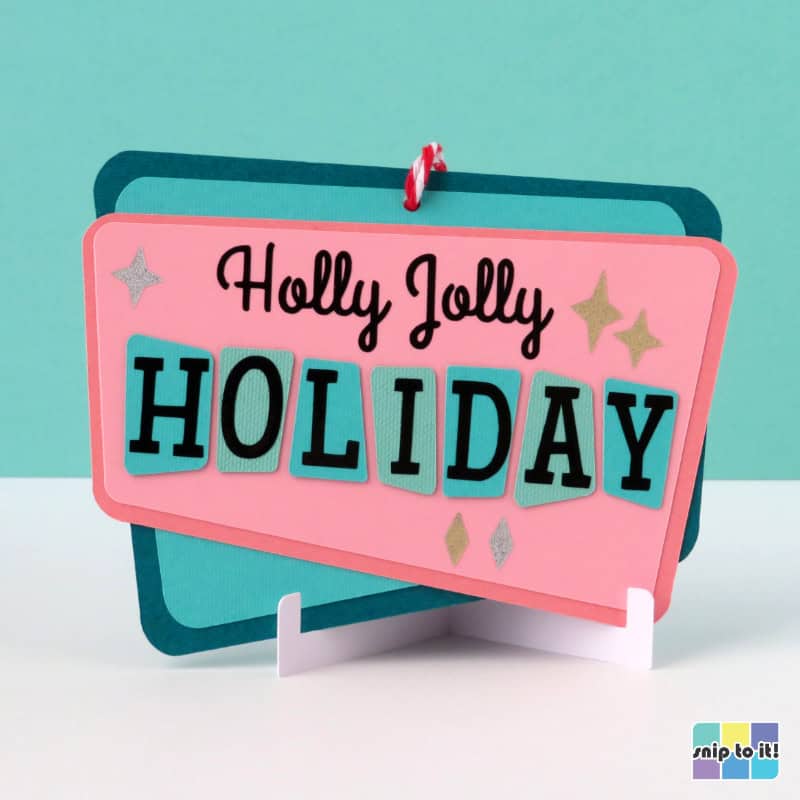gift card holder ornament in mid century style, made using pink, turquoise, and mint cardstock and saying "Holly Jolly Holiday" in the style of a vintage sign