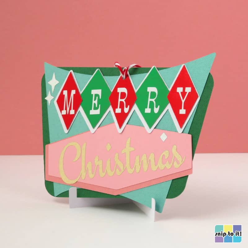 gift card holder ornament in mid century style, made using pink, red, green, and mint cardstock and saying "Merry Christmas" in the style of a vintage sign