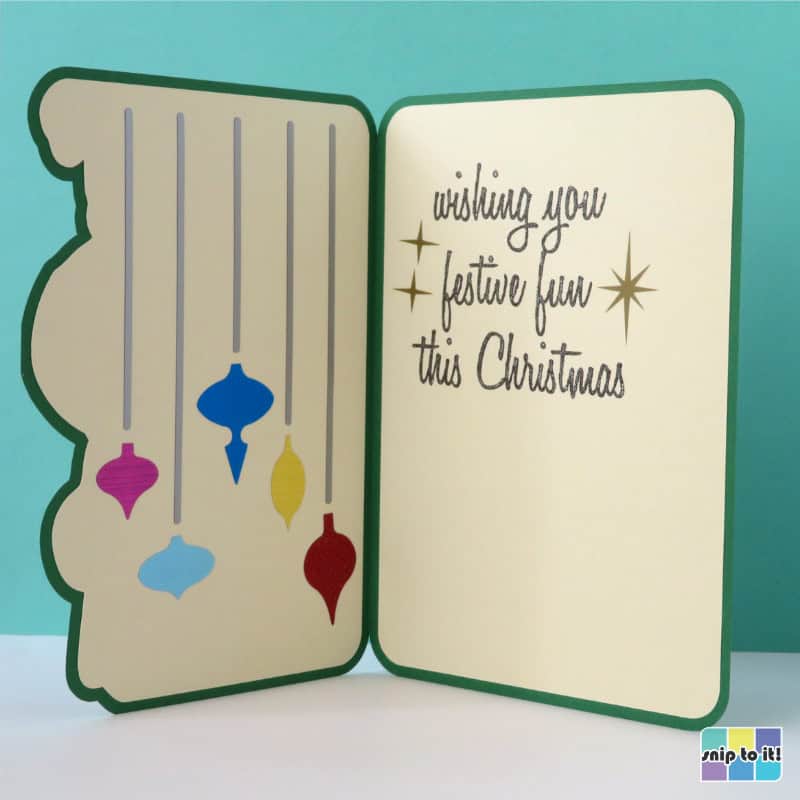 photo of the inside of the gesturing Santa christmas card, with sentiment written in pen and vintage ornament decorations