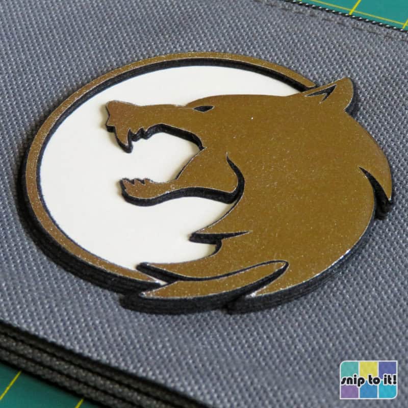 closeup of a 3D badge made up of multiple offset layers cut out of Siser Stripflock pro and Siser Metal HTV