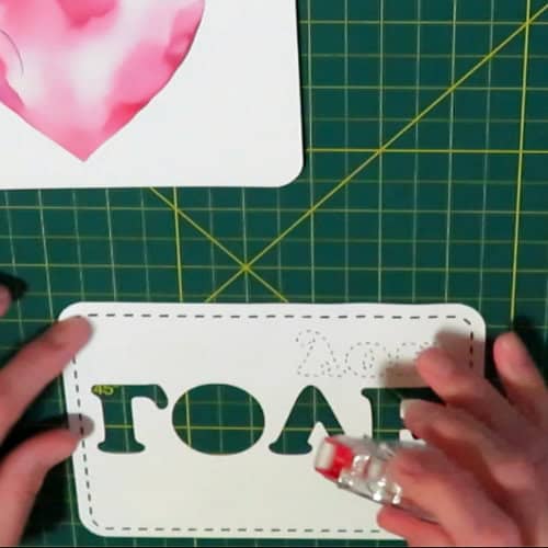 photo of using tape runner to apply adhesive to the back of a spacer layer for the recessed text eclipse card