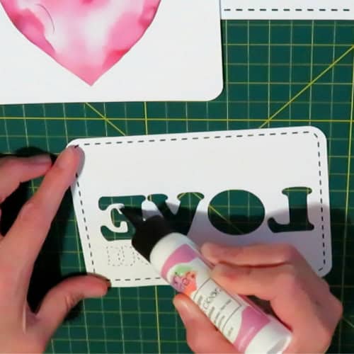 photo of applying glue around letters on the back of a spacer layer for the recessed text eclipse card