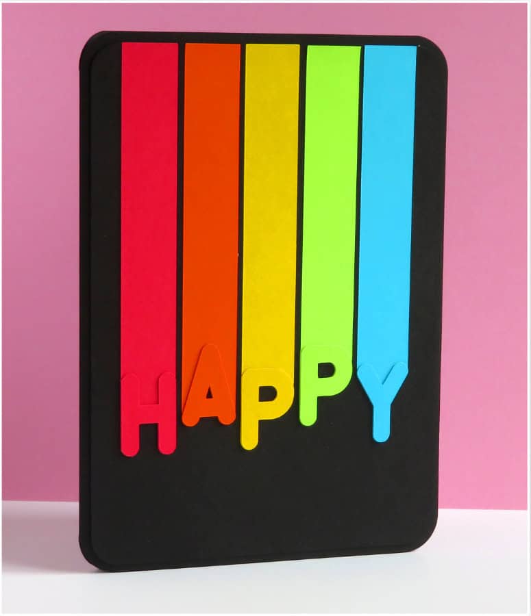 photo of front of finished rainbow birthday card, HAPPY in rainbow colors with corresponding vertical stripes above each letter