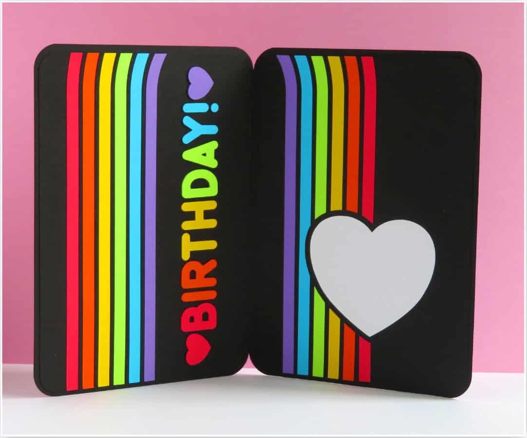 photo of inside of completed rainbow birthday card. rainbow stripes arc over both sides of the inside, with birthday in rainbow colors on one side and a white heart sentiment panel on the other side
