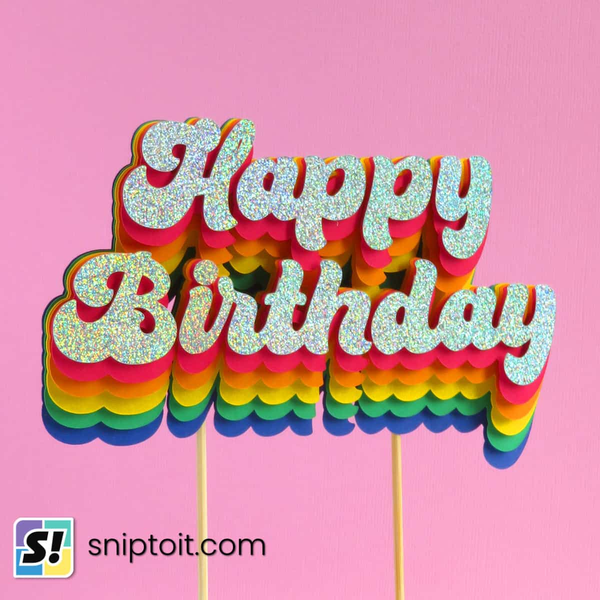 closeup photo of a layered cardstock birthday cake topper featuring a rainbow text effect