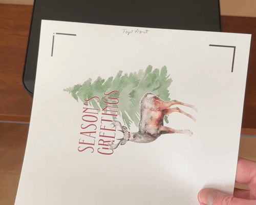 gif showing double sided printing for side edge christmas card. Front image is printed, then page is flipped side to side before loading headfirst into rear-loading printer, to print inside of card via design space