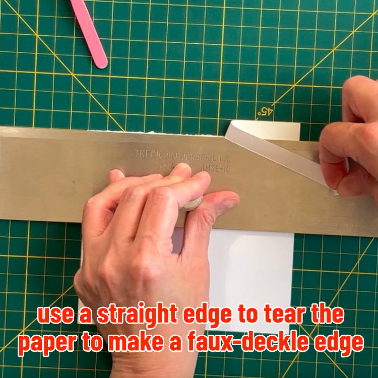 photo of process of making faux deckle edge, where Kerri is tearing the edge of the paper along a metal straightedge
