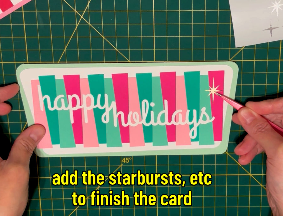 closeup image of a starburst cut out of shimmer vinyl being applied to the finished pink and green card with a pair of tweezers