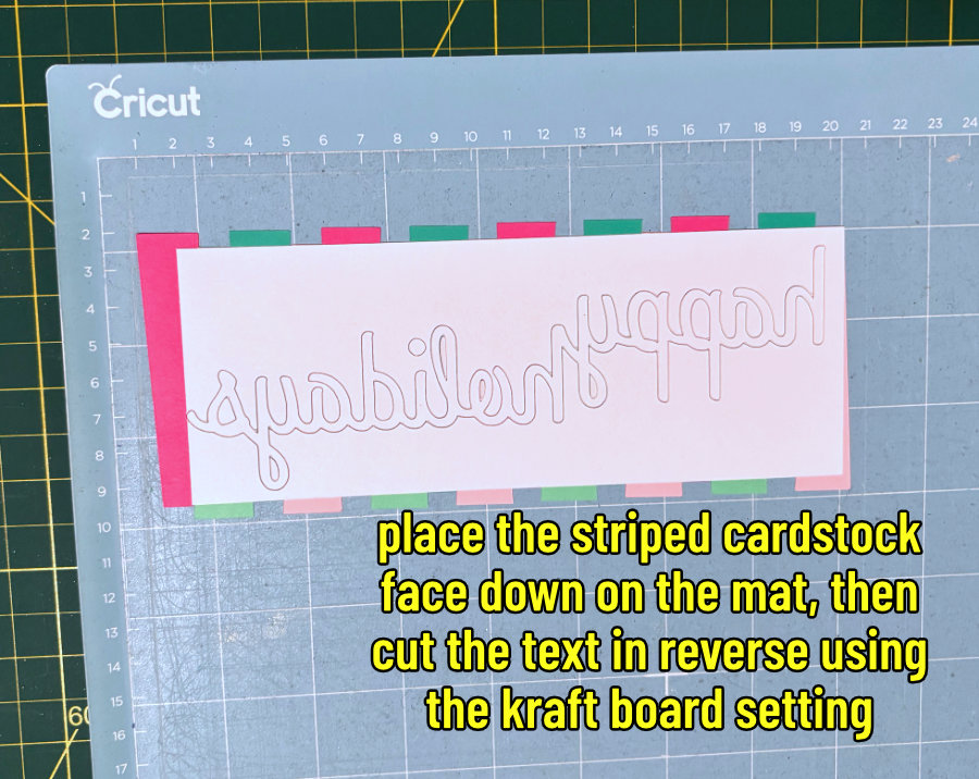 image of the words "happy holidays" cut in reverses from the back of a pink and green striped piece of cardstock