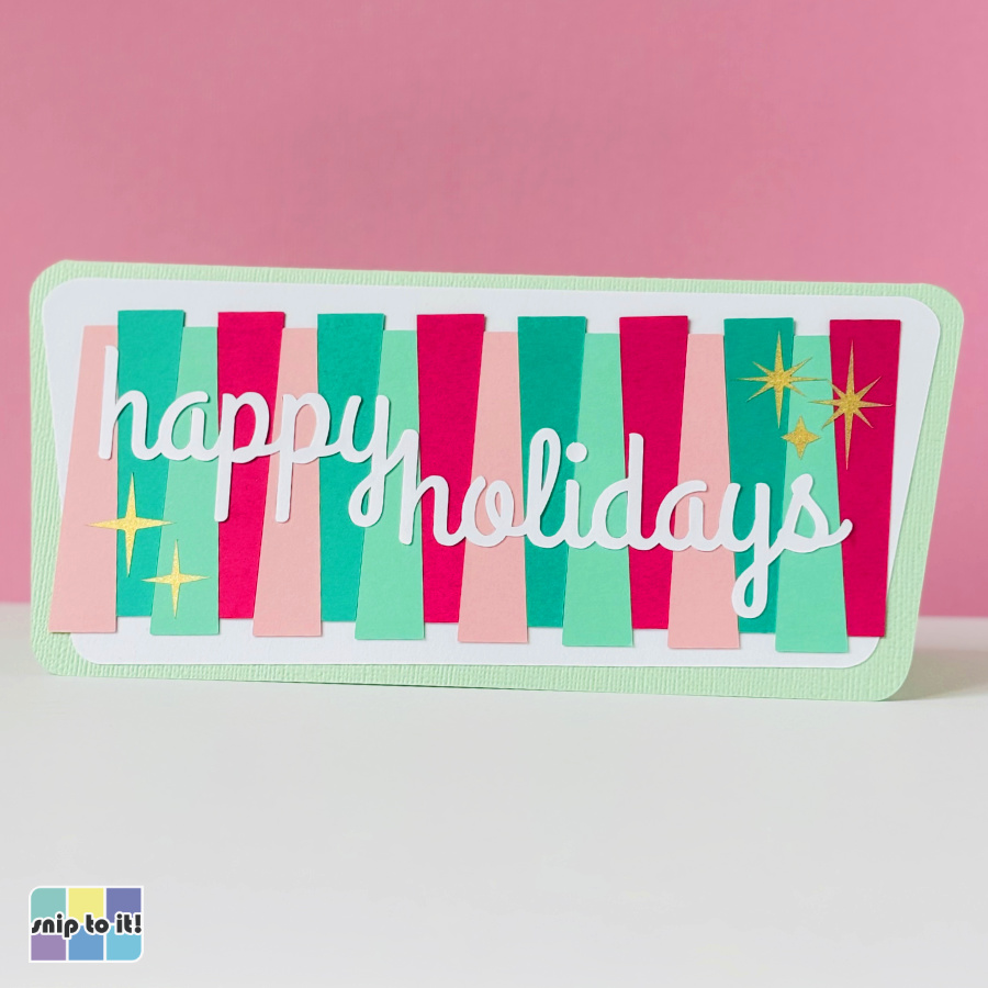 image of the finished pink and green MCM Christmas inlay card, featuring the words "happy holidays cut out of pink and green striped cardstock with white cardstock text inlaid in it's place. The finished card is embellished with gold and silver sparkle starbursts and set against a pastel pink background