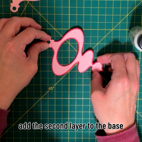 the second light pink layer of cardstock being glued on top of the base layer