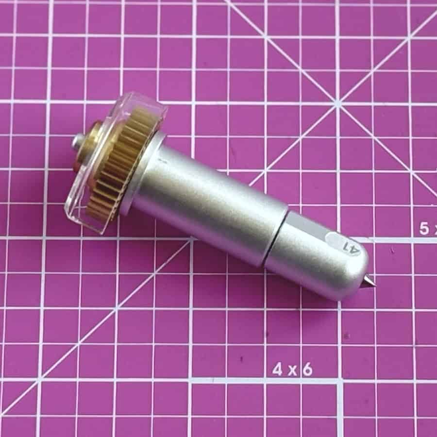 closeup image of the Cricut engraving tool on a pink cutting mat